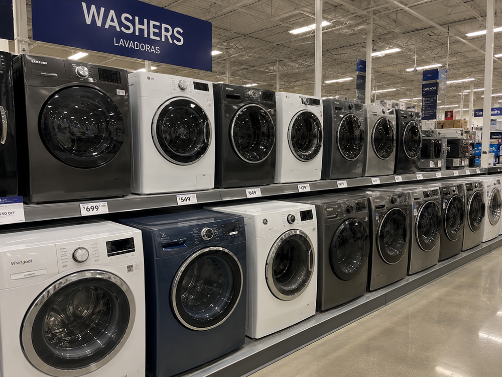 Toshiba washing machines on display in an appliance showroom with printed feature cards